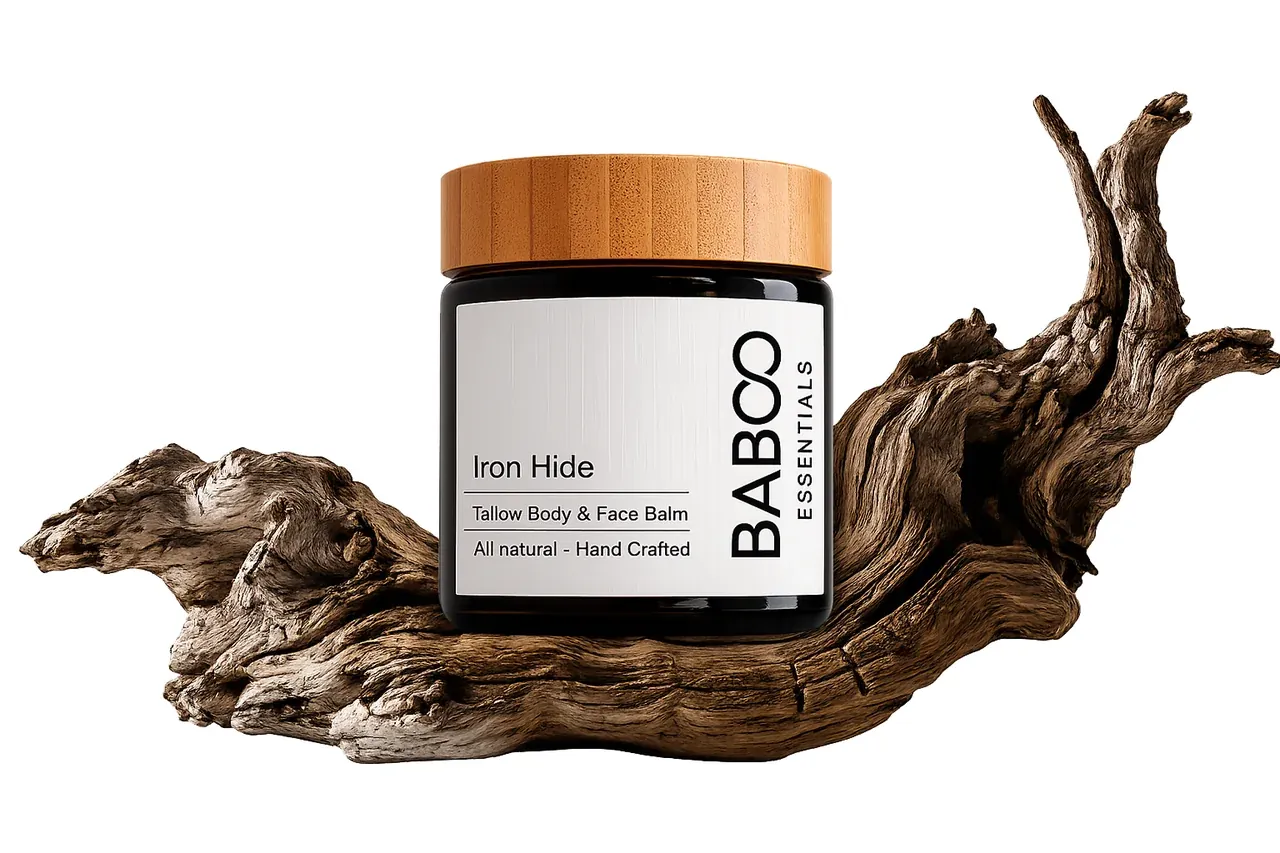 Iron Hide grass-fed tallow balm jar resting on driftwood